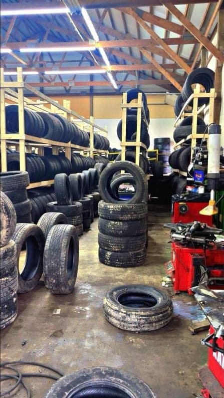 Aisle between tall racks filled with tires