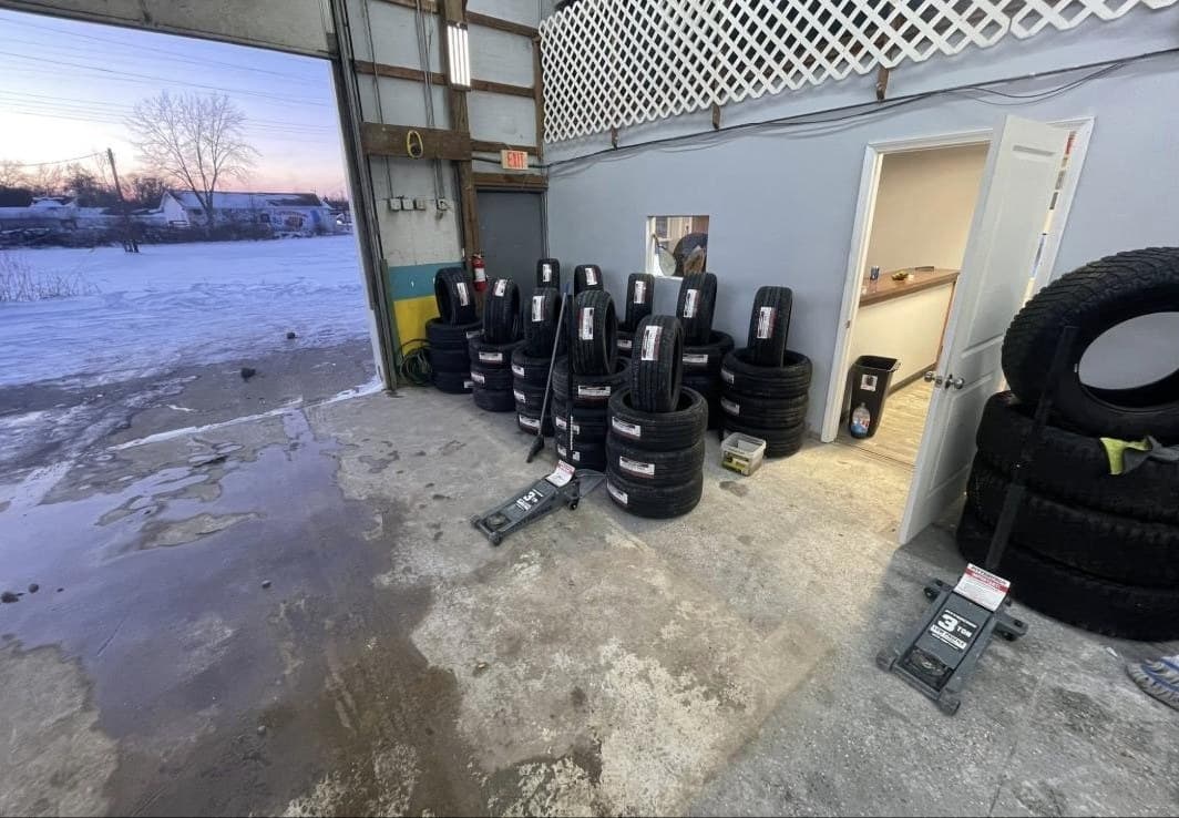 New tires lined up beside the open bay door at sunset